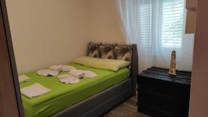 a small bed with green sheets and towels on it at Apartment KRISTINA in Dramalj