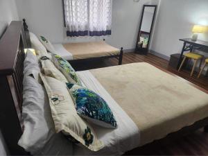 a bedroom with two beds with pillows on them at Matchi in Manila