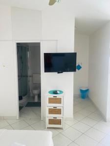Dieses weiße Zimmer verfügt über einen TV an der Wand. in der Unterkunft Apartments Milicevic in Rogoznica