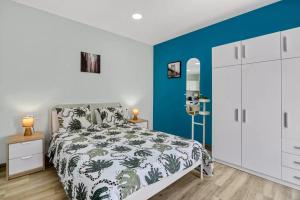 um quarto com uma cama e uma parede azul em Umihouse apartamentos centro Alicante em Alicante