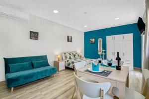 阿利坎特Umihouse apartamentos centro Alicante的客厅里有一张蓝色的沙发和一张桌子