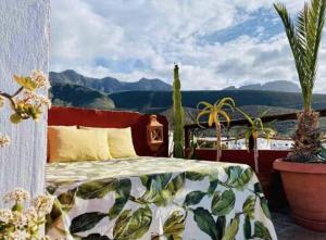 una camera da letto con un letto e piante in vaso su un balcone di CASTILLO LEON AGAETE ad Agaete