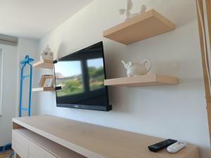 una camera con TV a parete e scaffali di Celeste - affitti brevi a Polignano a Mare