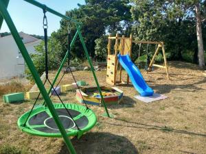 a playground with a slide and a swing set at Apartments Mira in Lopar