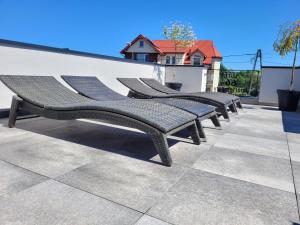 a row of benches sitting next to a wall at Loft 66 Apartamenty in Władysławowo