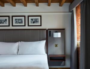 a bedroom with a bed and two pictures on the wall at Manchester Marriott Victoria & Albert Hotel in Manchester
