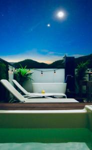 a couple of lounge chairs sitting on a balcony at night at Vacanza Resort in Gifu