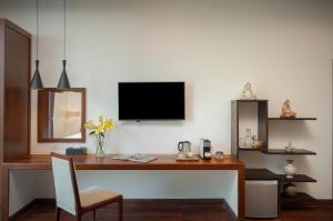 a desk with a television on a white wall at Shintana Saya Residence in Siem Reap
