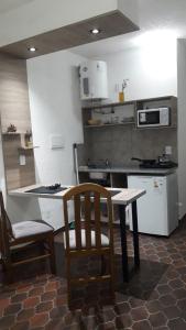 a kitchen with a table and a table and a chair at Departamentos Junin in San Fernando del Valle de Catamarca