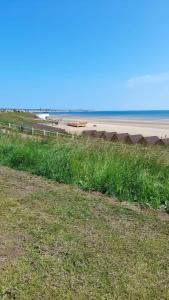a field of grass next to a beach with the ocean at Lovely 2-Bed Apartment in Bridlington in Bridlington