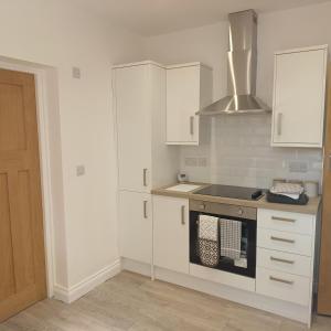 a kitchen with white cabinets and a stove top oven at Lovely 2-Bed Apartment in Bridlington in Bridlington