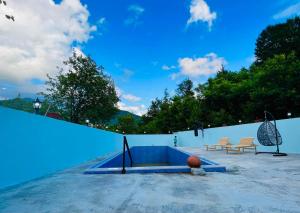 uma piscina azul com duas cadeiras e um banco em guest hause giorgi,kobuleti- xala em Itʼkhvisi