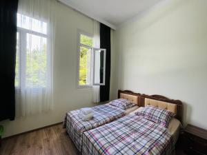 una camera da letto con un letto e due finestre di guest hause giorgi,kobuleti- xala a Itʼkhvisi