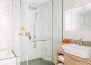 W łazience znajduje się szklana kabina prysznicowa i umywalka. w obiekcie Sonder Downtown Towers w Dubaju