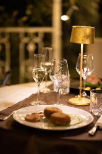 een tafel met een bord eten en wijnglazen bij Alla Corte Delle Terme Resort in Viterbo