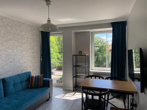 a living room with a blue couch and a table at Komfortowe mieszkanie w samym centrum. in Olsztyn