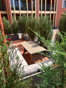 a picnic table in front of a building with plants at Rusnės Perlo apartamentai in Rusnė