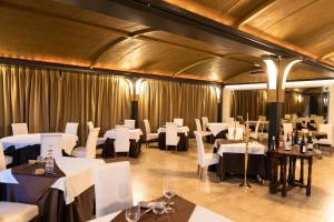 a dining room with white tables and white chairs at Phi Hotel Corte delle Terme in Viterbo