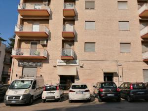 un grupo de coches estacionados frente a un edificio en Casa Vacanze Cozy House Matera, en Matera