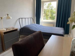 a bedroom with a bed and a table and a window at Komfortowe mieszkanie w samym centrum. in Olsztyn