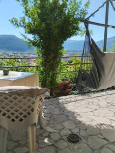 a patio with a hammock and a table and a view at Guesthouse Panorama in Mostar