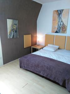 a bedroom with a bed and two paintings on the wall at Apartment Sova in Ostrava