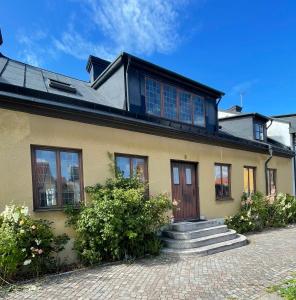 een geel huis met een trap ervoor bij Trerummare med panoramautsikt och balkong i Visby innerstad in Visby