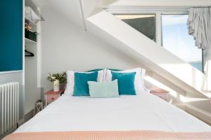 a bedroom with a white bed with blue pillows at Sea View Cottage Dream By The Water in Appledore