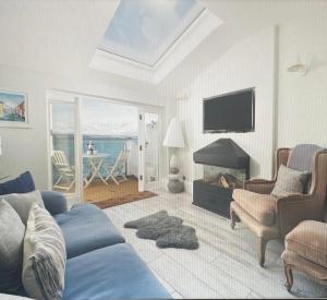 a living room with a blue couch and a television at Sea View Cottage Dream By The Water in Appledore
