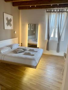 a bedroom with a large bed with wooden floors and windows at Cattedralflats in Bari