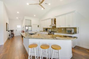 a kitchen with white cabinets and wooden stools at Serene Pahrump Cottage with Mountain Views! in Pahrump