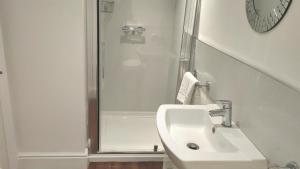a white bathroom with a shower and a sink at The Trusty Servant Inn in Lyndhurst +14 photos