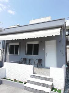 a house with stairs and a porch with a white door at Family Inn in Athens