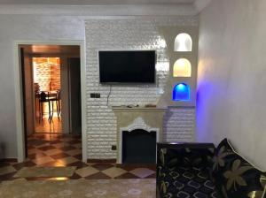 a living room with a fireplace with a tv above it at 100m² avec parking gratuit proche de la plage in Mohammedia