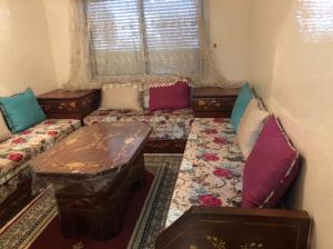 a room with two beds and a table and a window at 100m² avec parking gratuit proche de la plage in Mohammedia