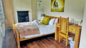 The Trusty Servant Inn في لِيندهيرست: سرير في غرفة مع مكتب وسرير سيد