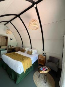 プエルトイグアスにあるGLAMPING SELVA IGUAZUのベッドルーム(大型ベッド1台、椅子付)