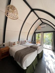 two beds in a room with two windows at GLAMPING SELVA IGUAZU in Puerto Iguazú