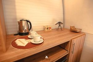 a wooden counter with a tea kettle and cups on it at GLAMPING SELVA IGUAZU in Puerto Iguazú