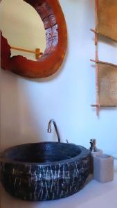La salle de bains est pourvue d'un grand lavabo en pierre et d'un miroir. dans l'établissement Afeto Caraíva, à Caraíva