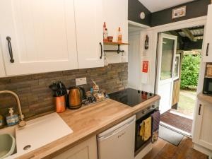 cocina con armarios blancos y encimera en Doirewood, en Newcastle Emlyn