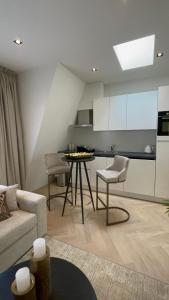 a living room with a couch and a table and a kitchen at Centrum Hilversum appartement in Hilversum