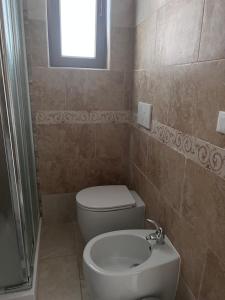リド・マリーニにあるCasavacanza La Reginaのバスルーム(トイレ、洗面台付)、窓が備わります。
