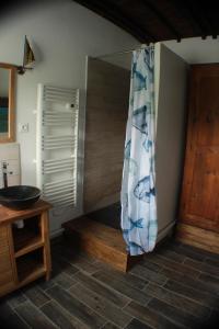 een badkamer met een douchegordijn en een houten vloer bij Péniche Espoir in Avignon