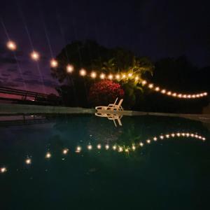 a plane in the water at night with lights at Chalé com vista incrível in São Roque