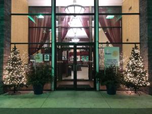 a store front with christmas trees in front of it at Crookston Inn & Convention Center in Crookston