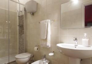 uma casa de banho com um lavatório, um WC e um espelho. em Affittacamere del Corso em Pienza