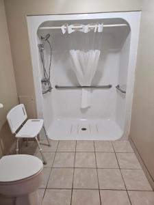 a bathroom with a toilet and a bath tub at Crookston Inn & Convention Center in Crookston