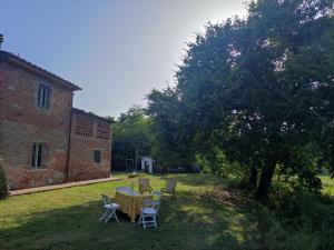 una mesa y sillas en un patio junto a un edificio en Appartamento Il Picchio Verde en Altopascio