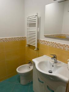 a bathroom with a sink and a toilet and a mirror at Ischia Dream Loft da Nancy in Ischia